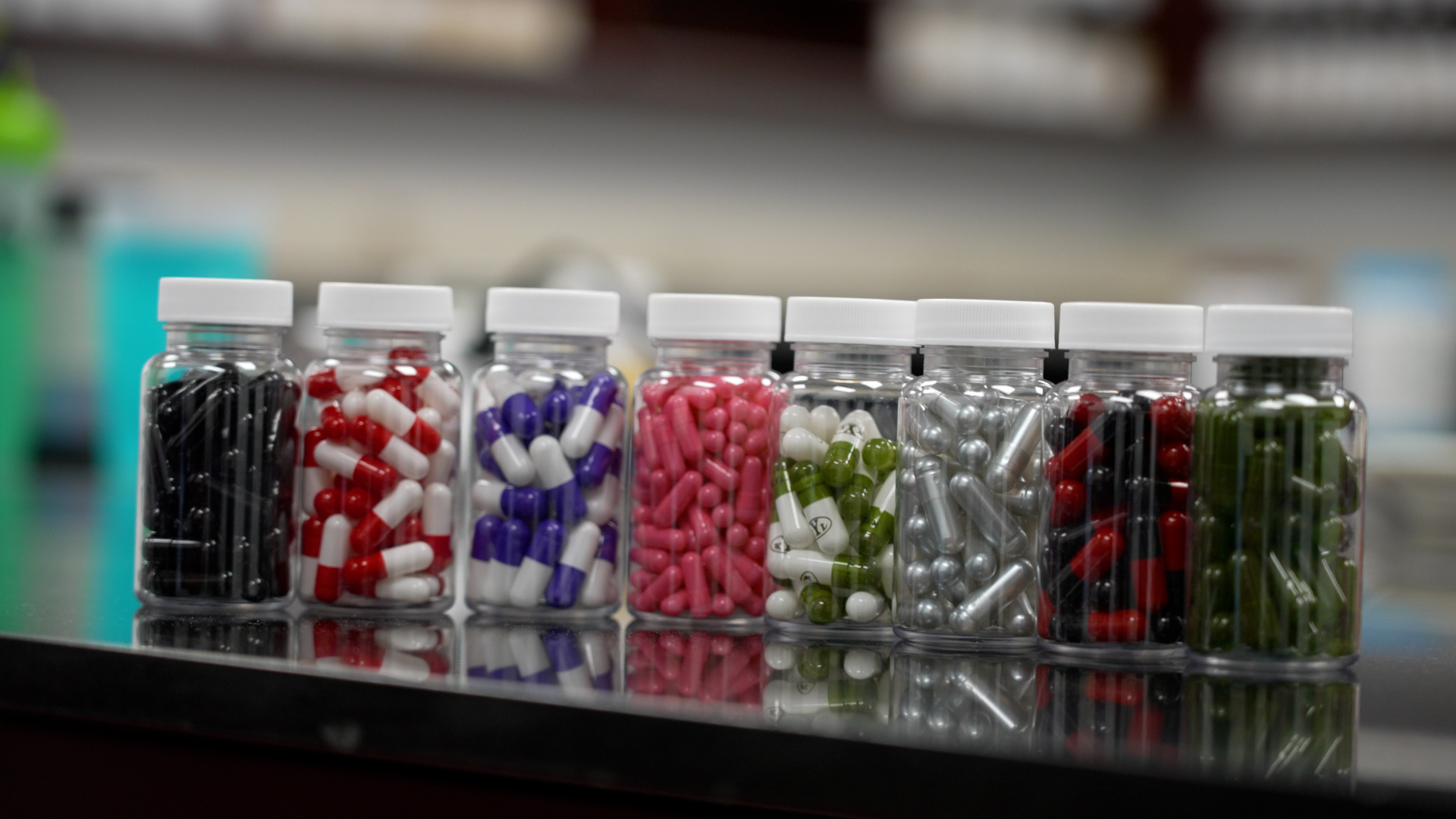 A sleek row of premium glass vitamin bottles with custom minimalist labels reflecting high-quality manufacturing.